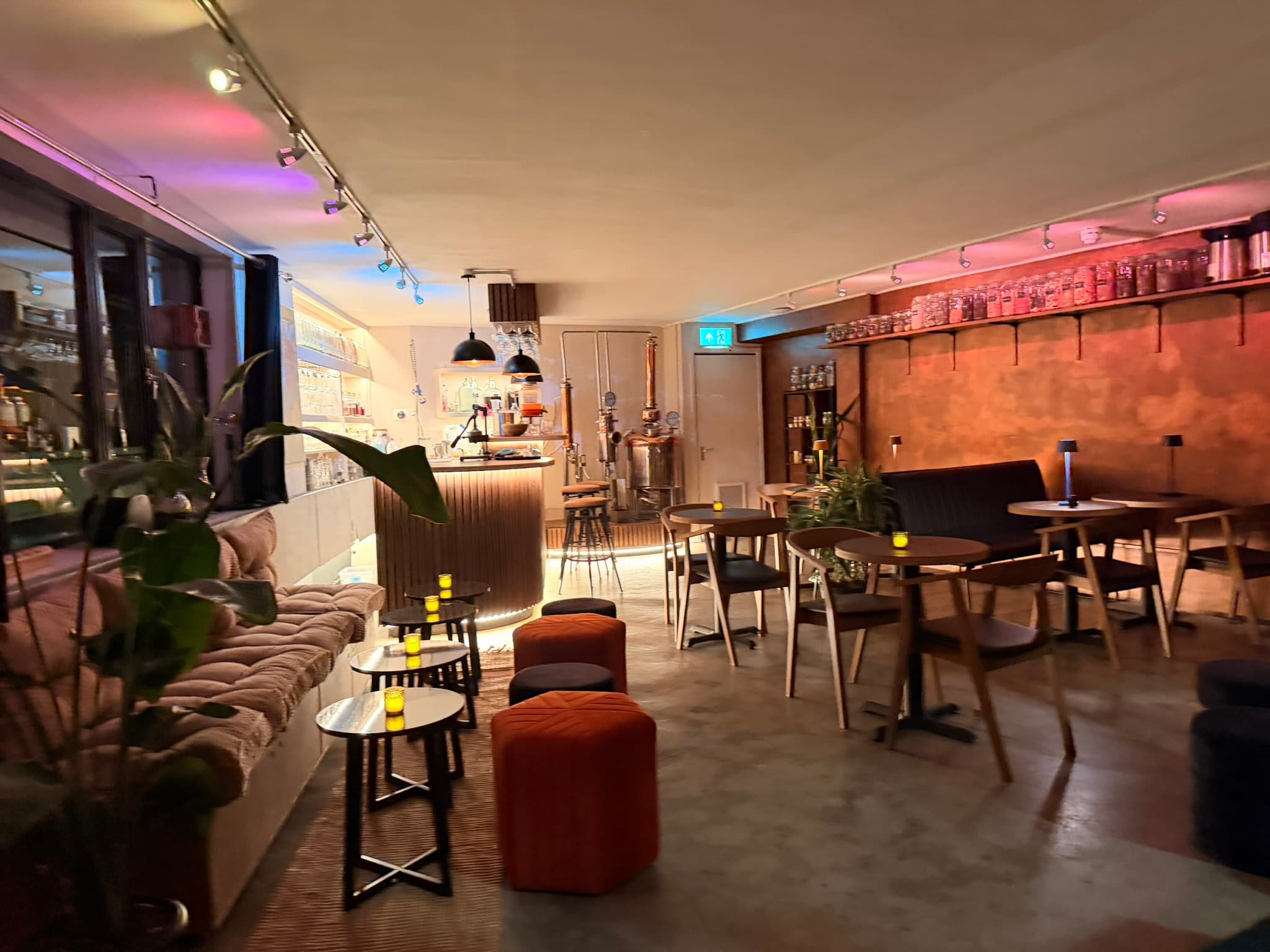 The BCC Distillery in the evening — copper still, timber bar, banquettes and warm lighting