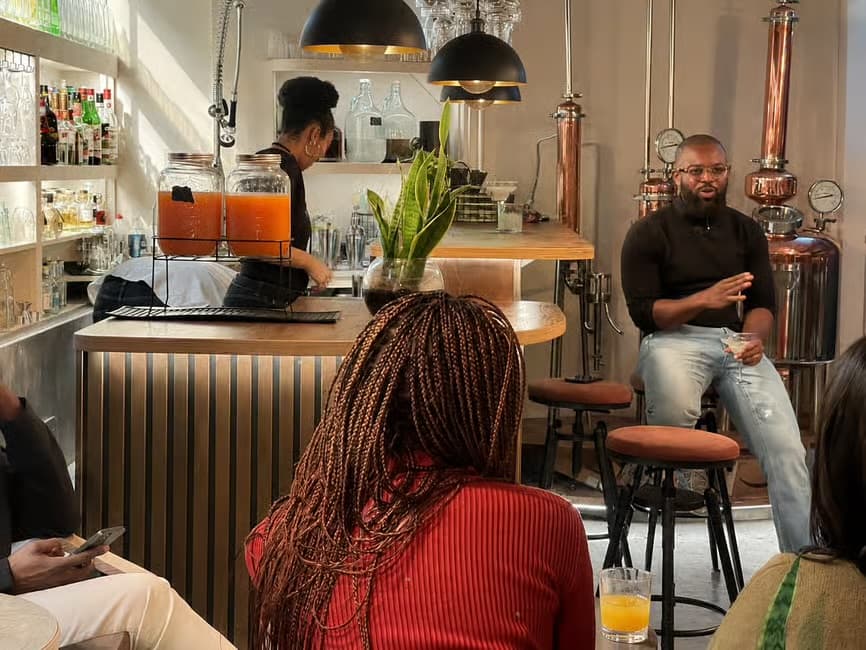 The room in conversation at the distillery bar — juices and botanical pours alongside the rum