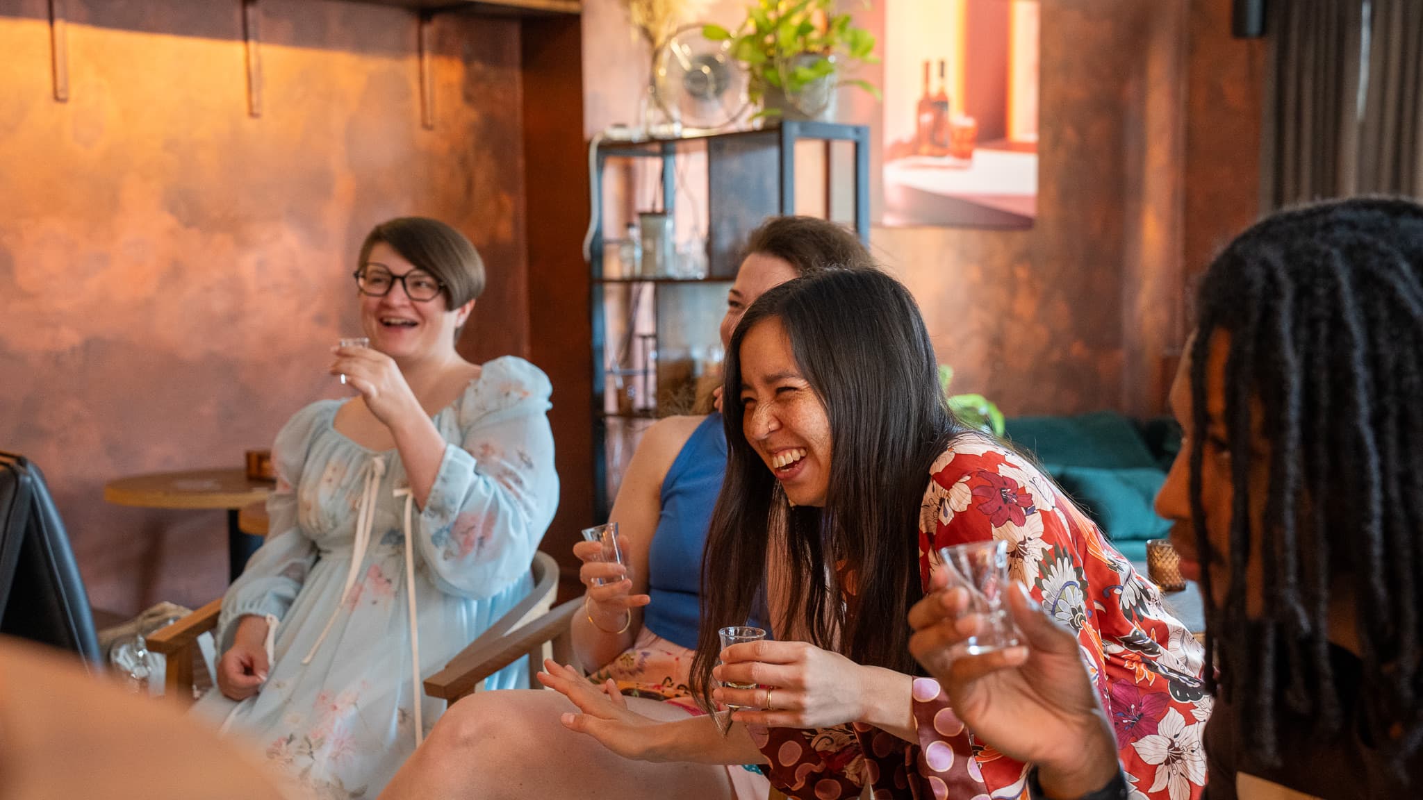 Guests laughing with tasting glasses in hand in the corner of the BCC Bar