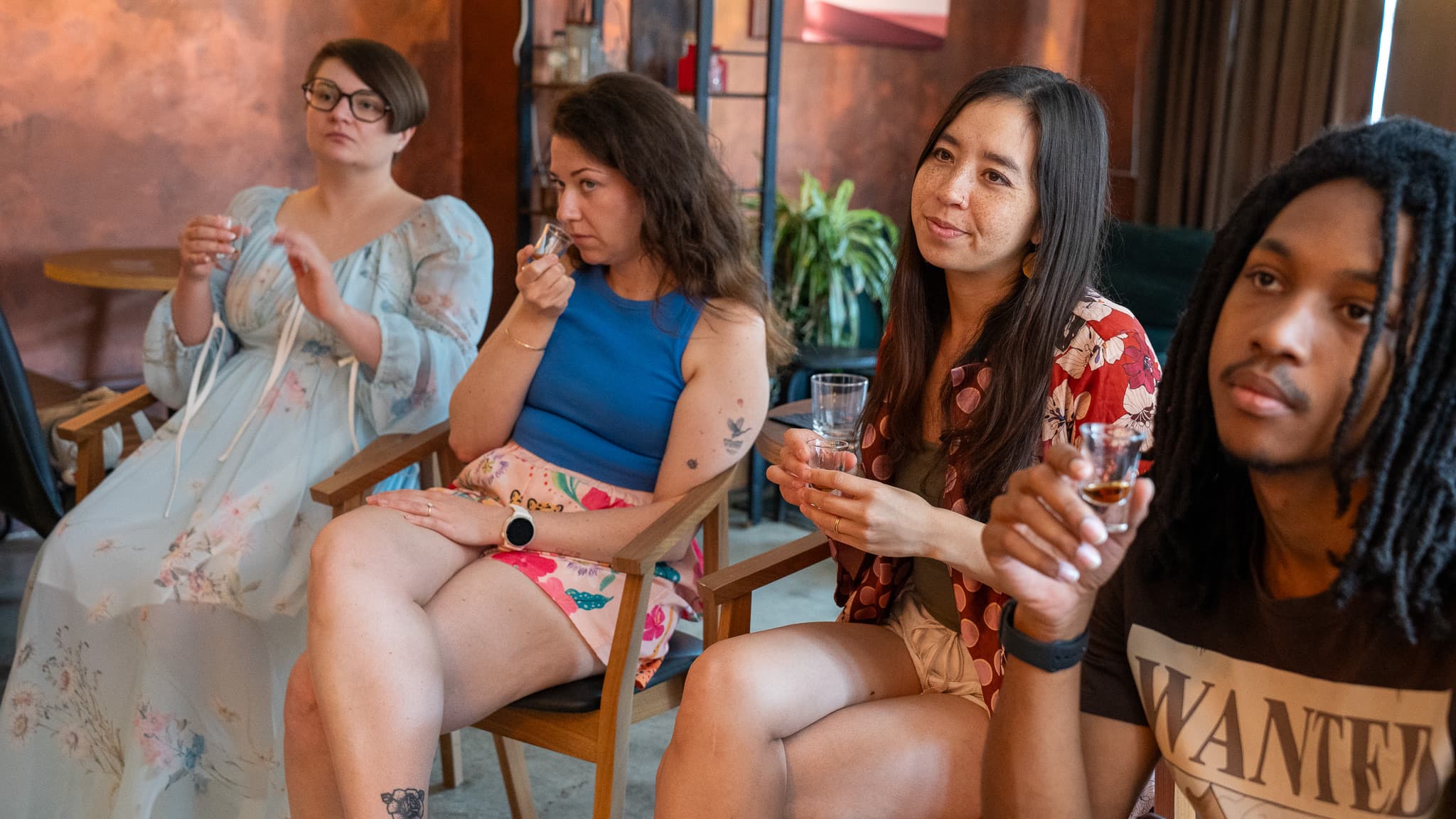 Four guests seated with tasting glasses, one nosing the rum