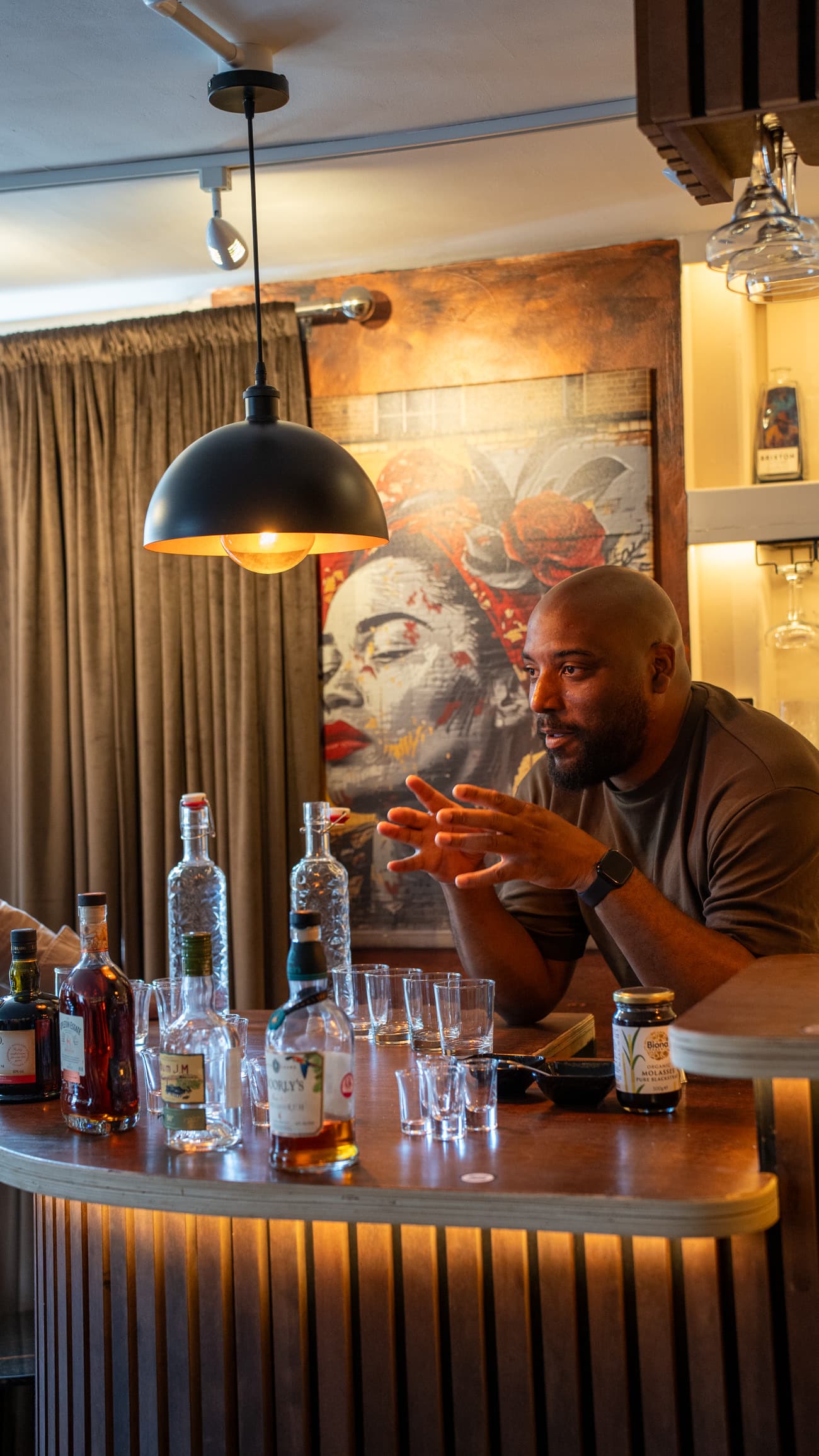 The host behind the bar explaining a rum, glasses lined up in front of him