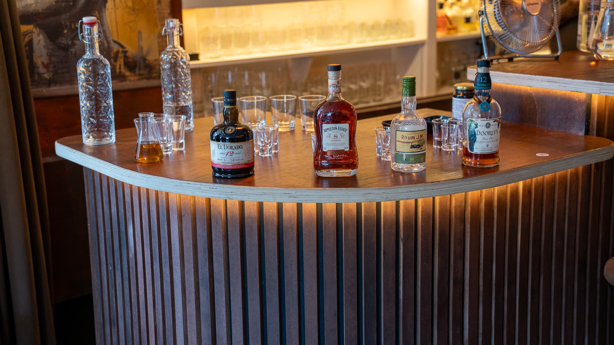 The rums lined up on the bar: El Dorado 12, Appleton Estate 8, Rhum J.M, Doorly's 12, and the tasting glasses